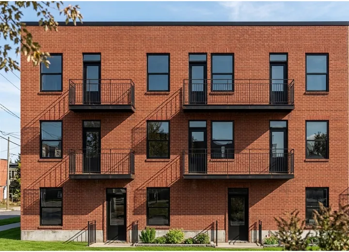 Façade de brique d'un immeuble multilogement avec balcons métalliques, portfolio Archidep